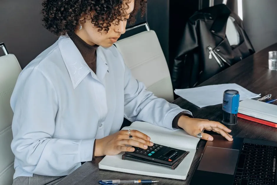 An accountant using a calculator while reviewing tax documents