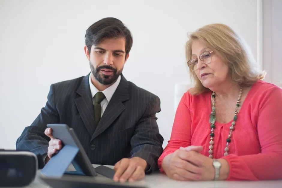 A tax professional reviewing paperwork with a client at a desk